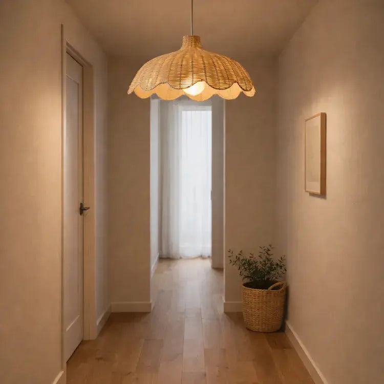 Suspension en rotin naturel HEDDA diffusant une lumière chaleureuse dans un couloir au style scandinave. 