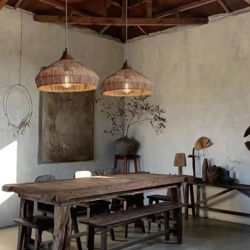 Deux suspensions en rotin Nella éclairant une table en bois dans une salle à manger au style nordique. 