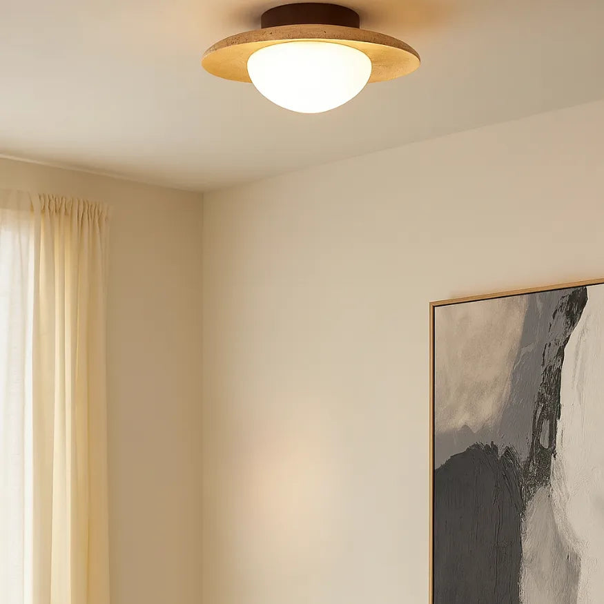 Plafonnier en travertin naturel et bois massif éclairant un salon au style scandinave, lumière douce et ambiance chaleureuse.